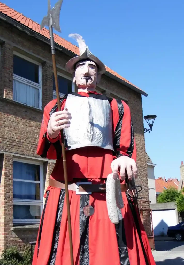 Le géant Gomez portant une paire de saucisses de Bergues dans sa main (C) OT Hauts-de-Flandre